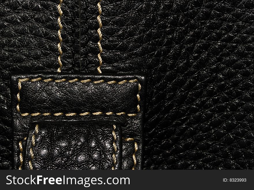 Black leather macro texture with light thread