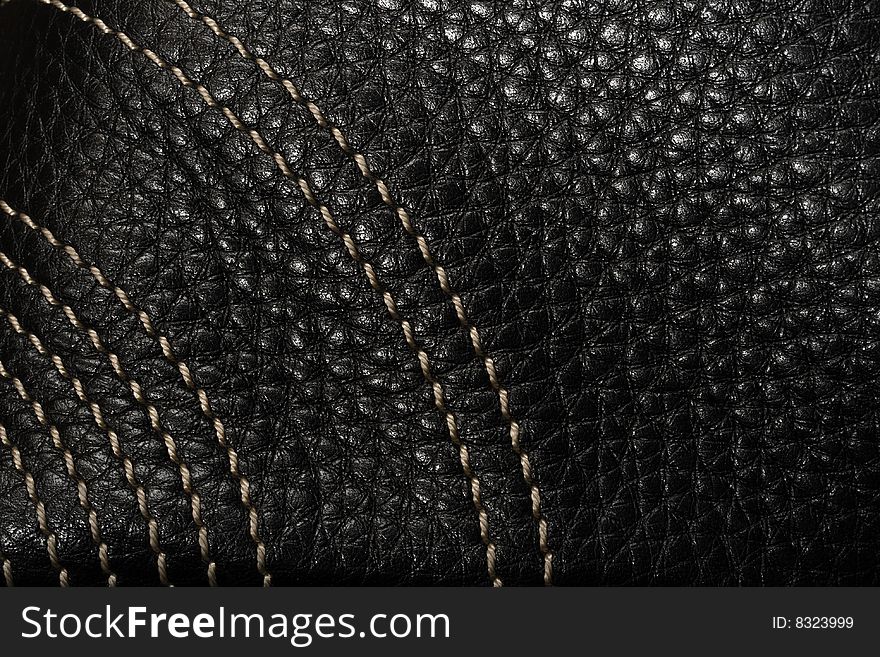 Black leather macro texture with light thread