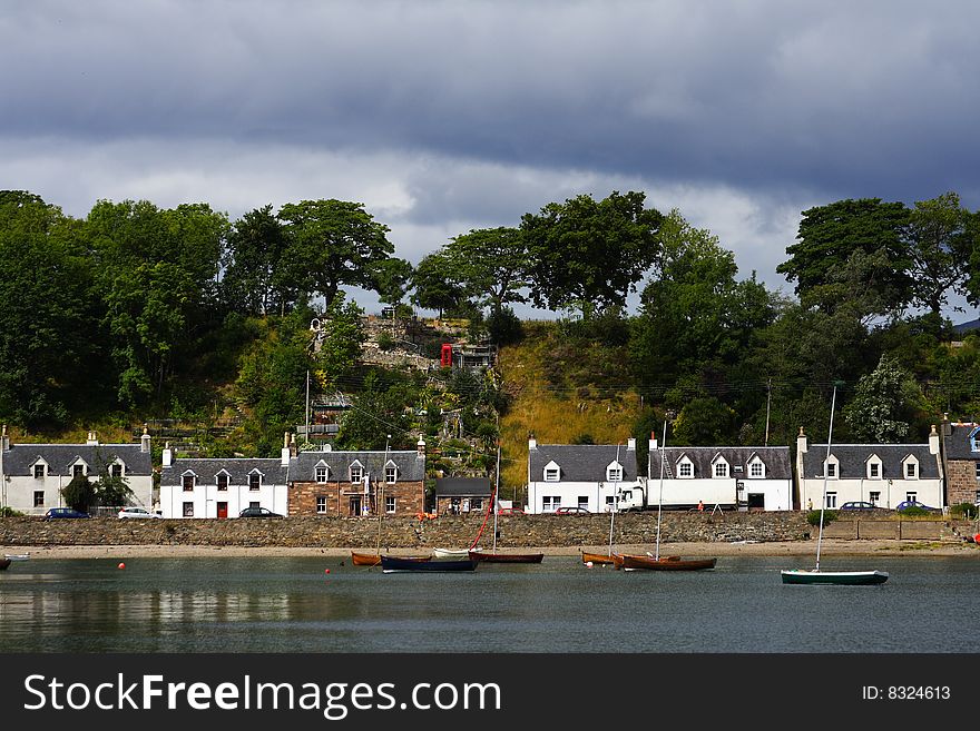 Plockton village and loch carron in scotland during summer with sailing boats at first plan. Plockton village and loch carron in scotland during summer with sailing boats at first plan