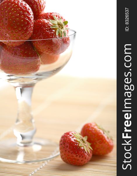 Ripe strawberries in glass bowl isolated