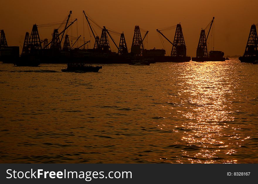 Cargo port with industrial cranes against sunset sky. Cargo port with industrial cranes against sunset sky