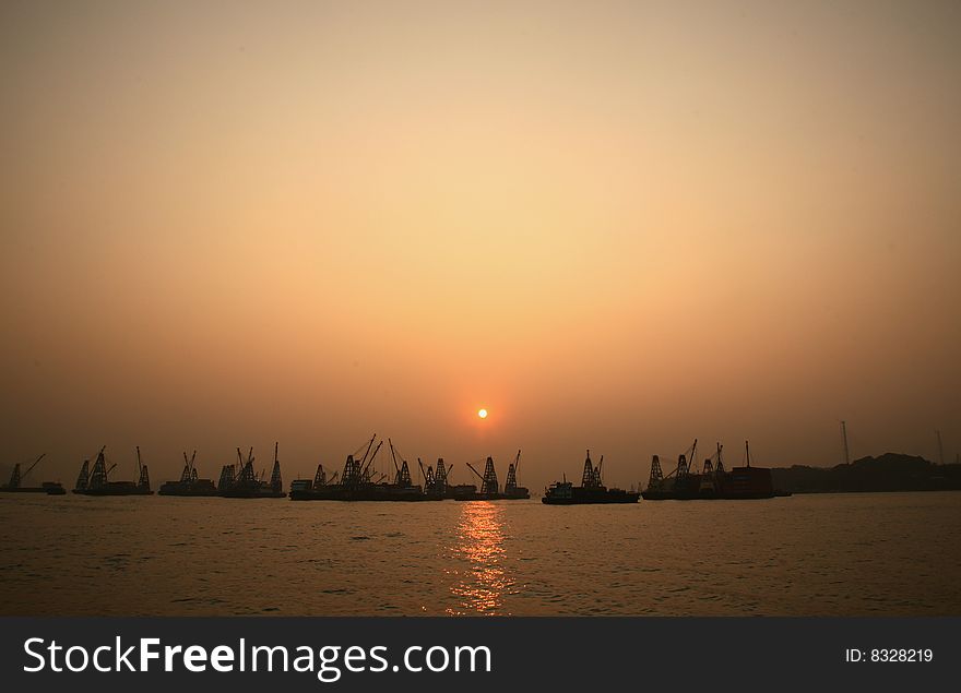Cargo port with industrial cranes against sunset sky. Cargo port with industrial cranes against sunset sky