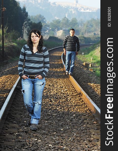 Young couple walking on railway tracks