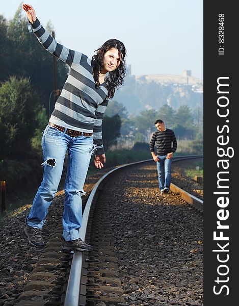 Young couple walking on railway tracks