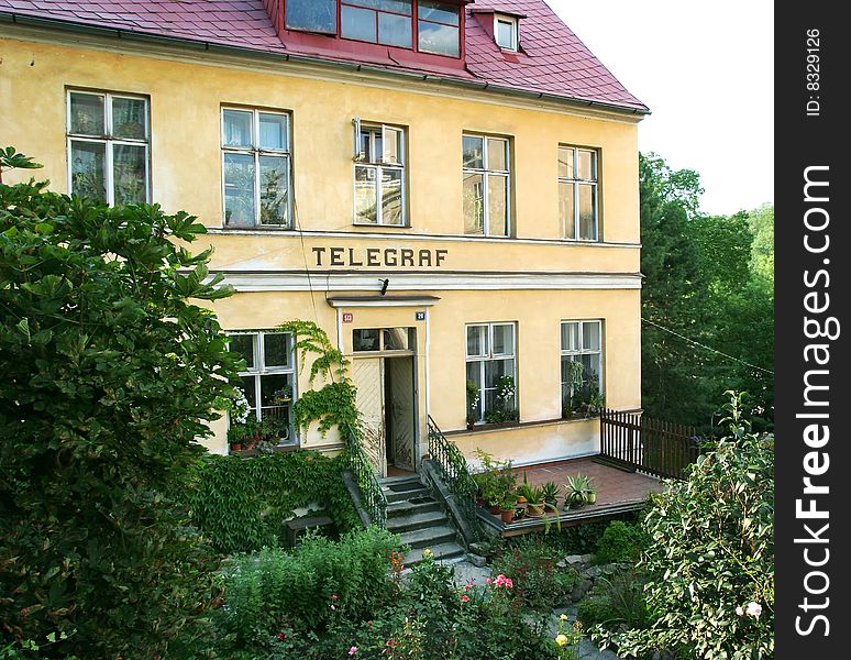 Provincial telegraph building in green yard with flowers