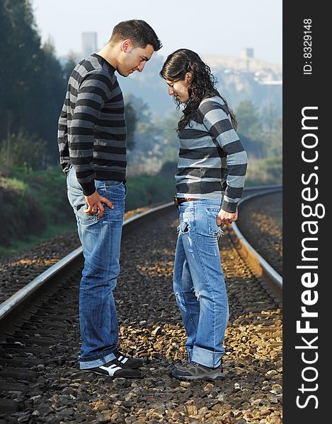 Young couple looking each other on railway tracks. Young couple looking each other on railway tracks