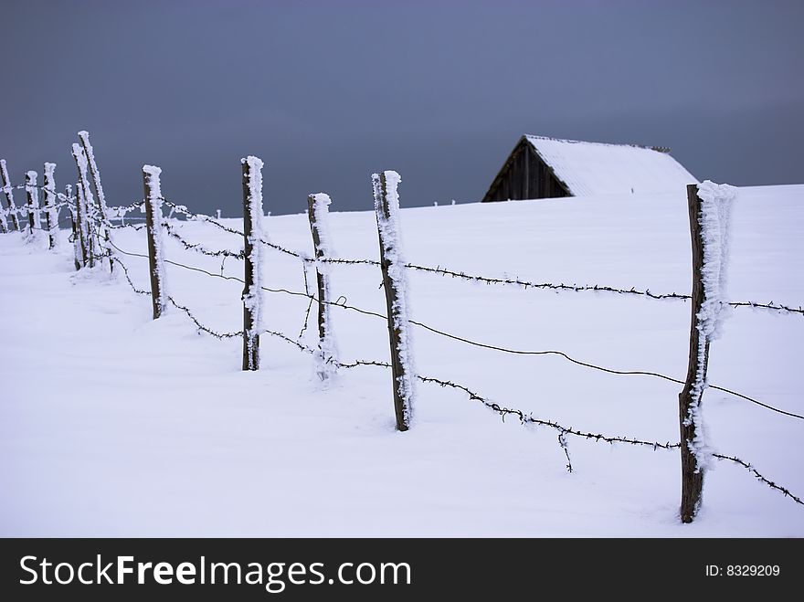 Winter landscape;Lonley house with fence in a village in the mountains,in Romania