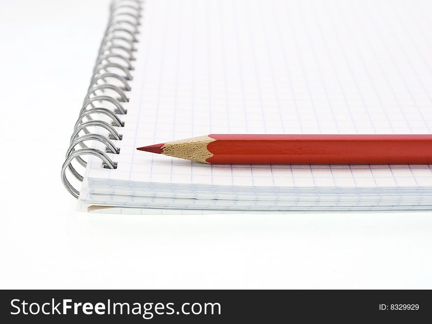 Spiral notepad with red pencil on white