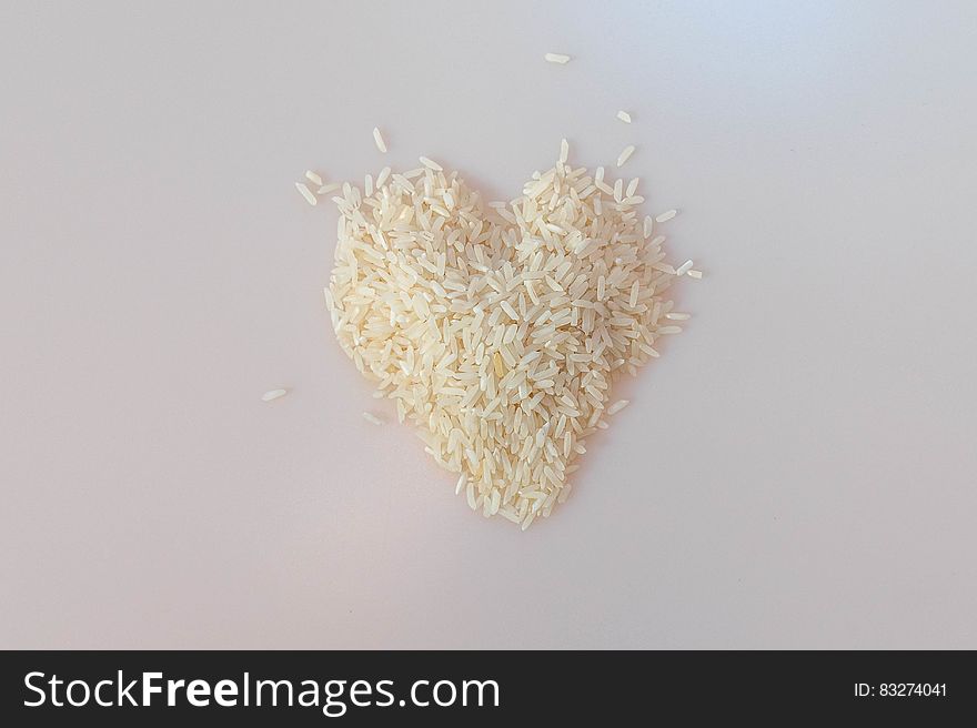 A pile of uncooked rice in form of a heart. A pile of uncooked rice in form of a heart