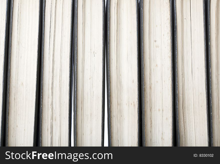 Close-up of a row of old marked antique books, leather-bound with white background light through the gaps between books. Close-up of a row of old marked antique books, leather-bound with white background light through the gaps between books
