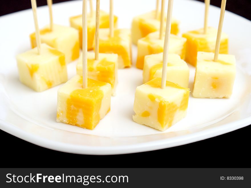 A plate of cheese cubes with toothpicks.