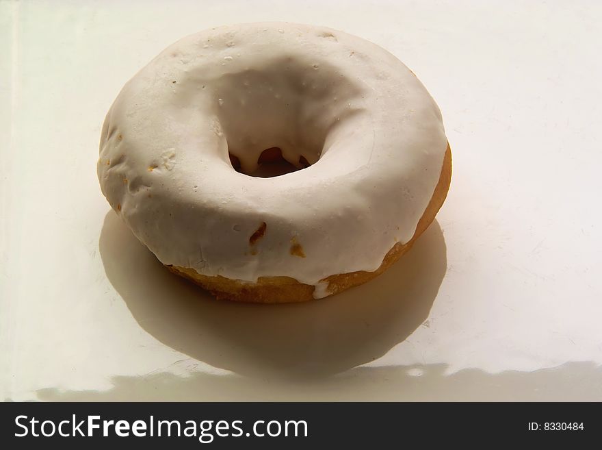 Donut with white Covering on a white Plate