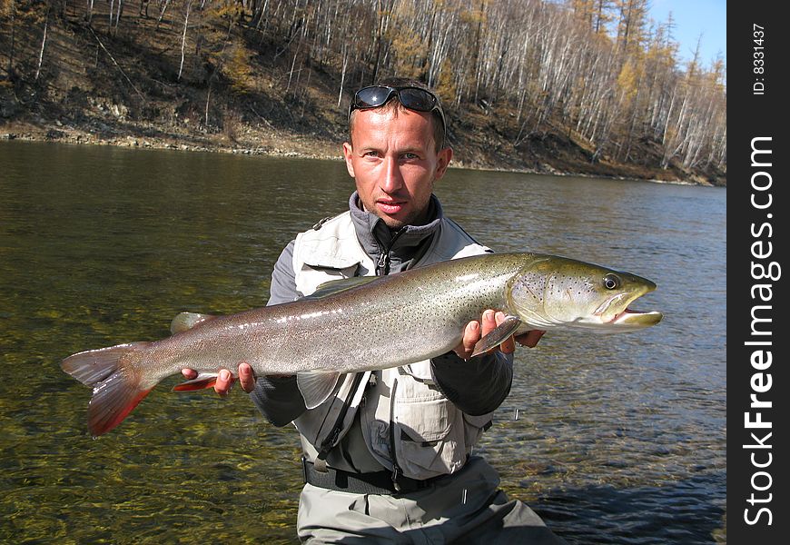 Fisherman with fish (Taimen fishing in Mongolia)