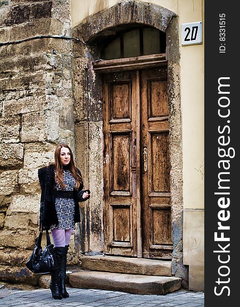 Stock photo: an image of a nice woman standing at old door. Stock photo: an image of a nice woman standing at old door