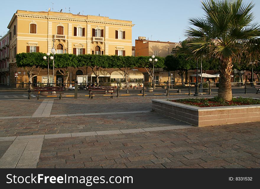 Mediterranean square with palms and big palace