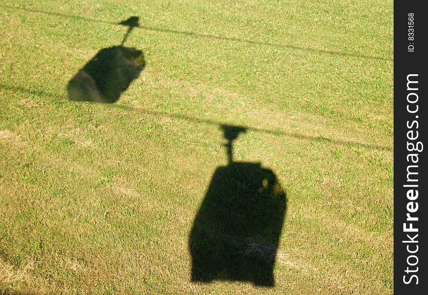 Shadows of cable cars on the grass. Shadows of cable cars on the grass