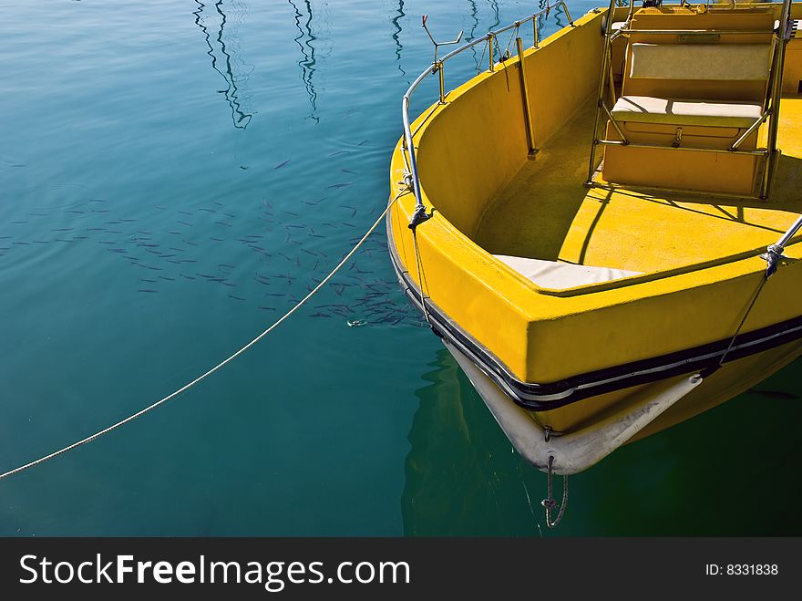 Moored yellow boat in a marina water area. Moored yellow boat in a marina water area