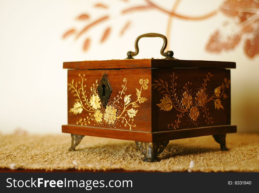 Antique trinket box with golden inlays and lock, holding memories and secrets of times past. Antique trinket box with golden inlays and lock, holding memories and secrets of times past