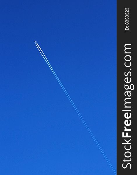 Flying plane with track on blue sky