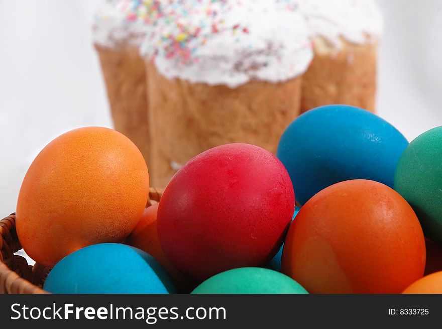 Colored easter eggs on a white background with Kulich