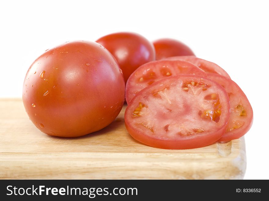 Fresh sliced tomatoes on a cutting board with white background and copy space. Fresh sliced tomatoes on a cutting board with white background and copy space