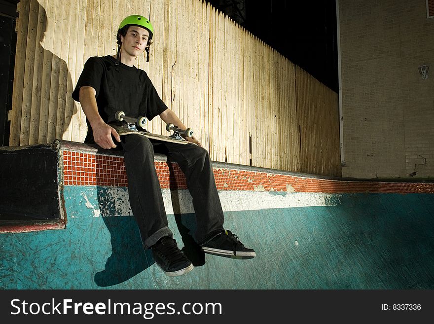 Skateboarder Sitting On Top Of Mini Ramp