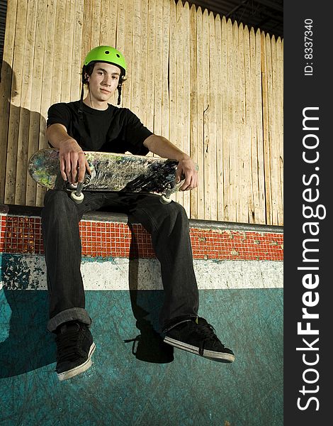 Young Skateboarder Sitting On Ramp