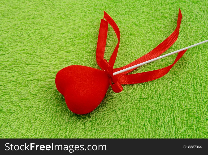 red heart with ribbons on soft green surface. red heart with ribbons on soft green surface