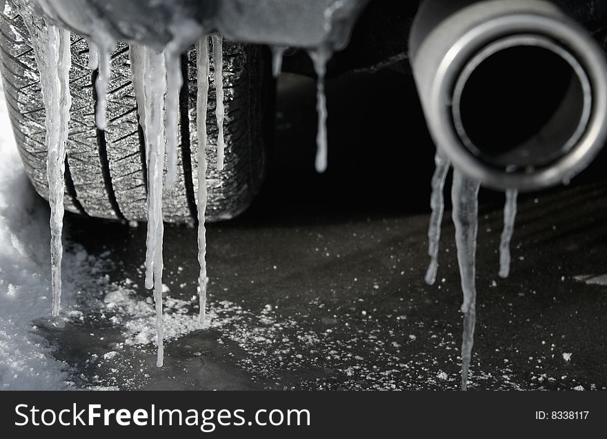 Icicles hanging from the bumper of a neglected car during winter. Icicles hanging from the bumper of a neglected car during winter.