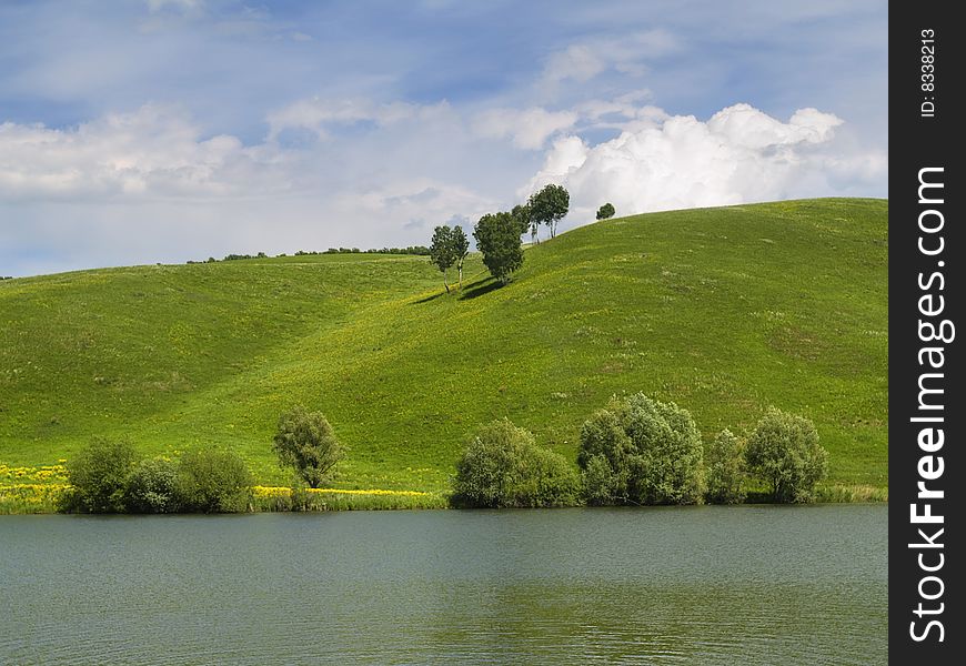 Mountain with a bright green grass of the shore of Lake. Mountain with a bright green grass of the shore of Lake