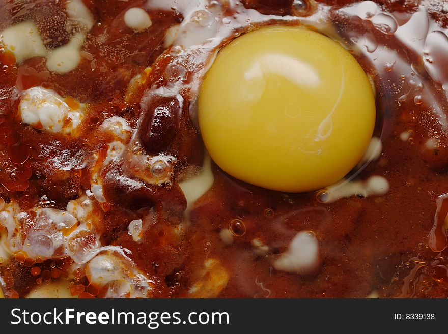 Eggs and red beans in the chili sauce fry on the skillet. Narrow depth of field. Eggs and red beans in the chili sauce fry on the skillet. Narrow depth of field.