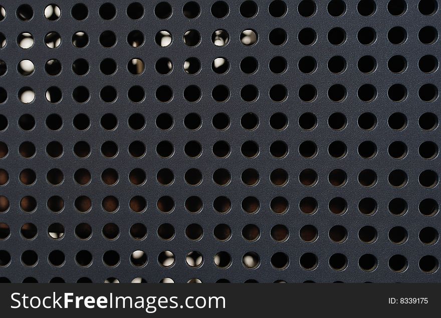Plastic grille with round holes on the black background. Plastic grille with round holes on the black background.