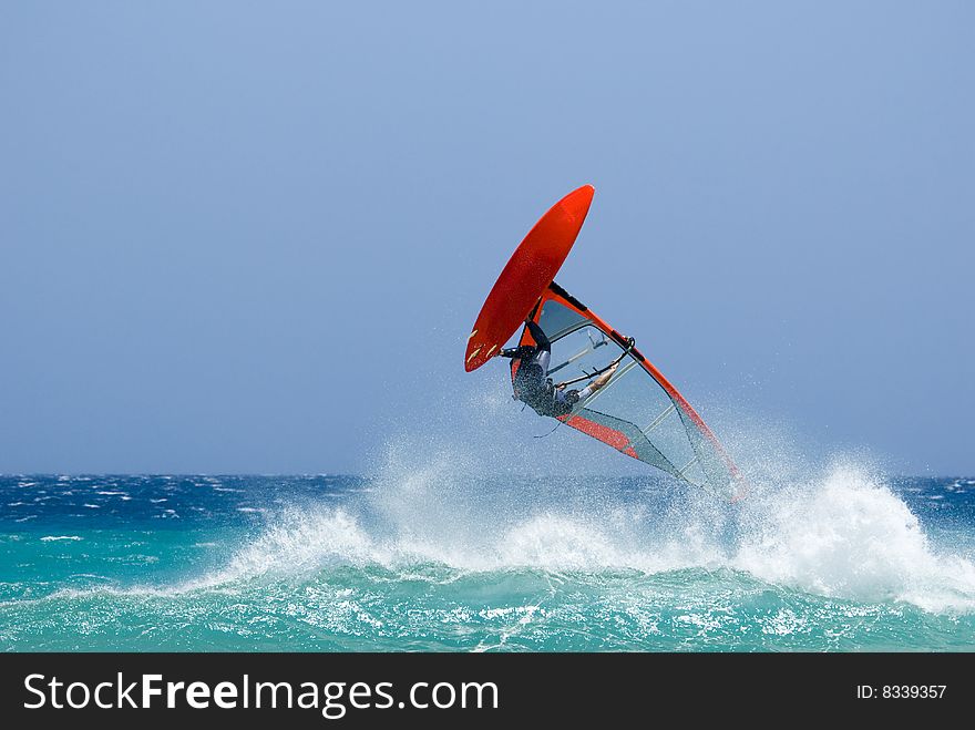 An acrobatic jumping windsurfer in the ocean. An acrobatic jumping windsurfer in the ocean