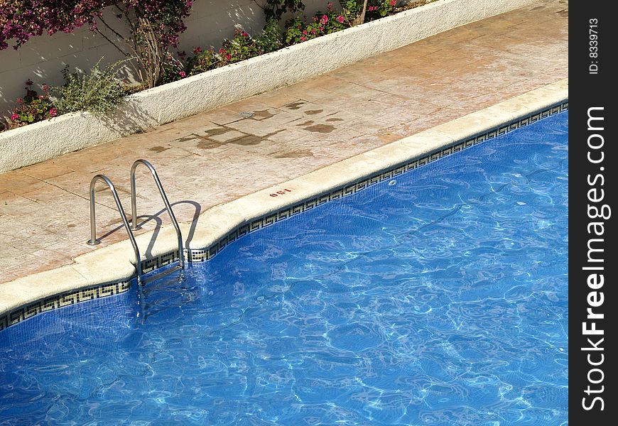 Swimming pool entrance with metal hand rail