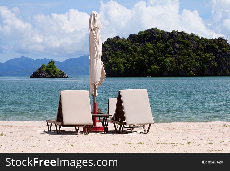 Sunbeds and parasols on a sandy beach in Langkawi, Malaysia. Sunbeds and parasols on a sandy beach in Langkawi, Malaysia