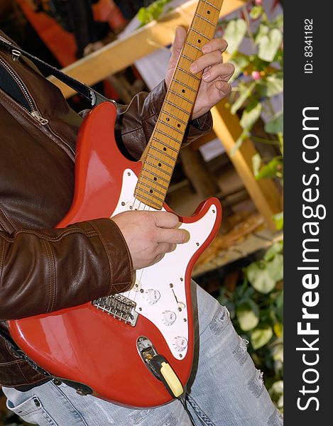 Musician plays on a red electric guitar. Musician plays on a red electric guitar