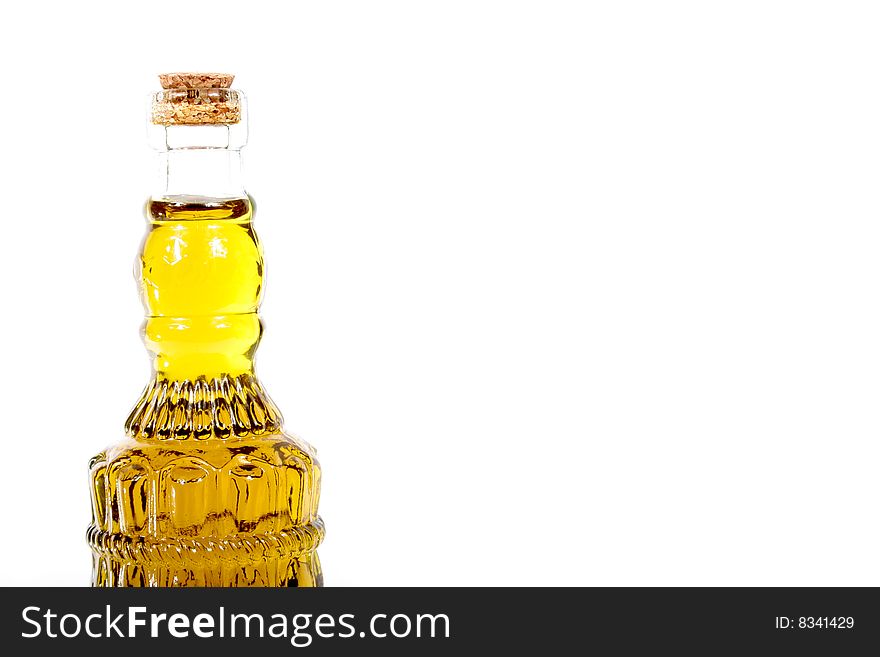 A fancy glass bottle filled with olive oil on a white background. A fancy glass bottle filled with olive oil on a white background.