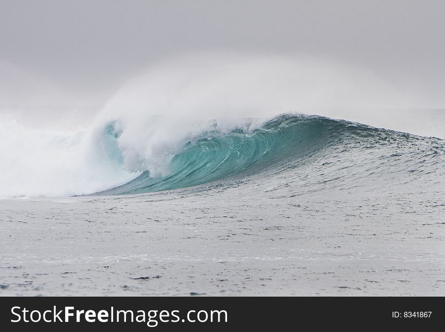 Big wave breaks over a reef