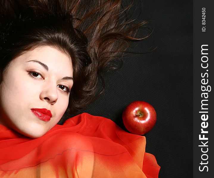 Portrait of the beautiful girl with an apple and developing hair. Portrait of the beautiful girl with an apple and developing hair.