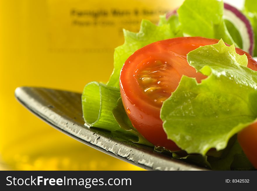 Healthy fresh salad isolated on plate. Bottle of olive oil on background. Healthy lifestyle. Healthy fresh salad isolated on plate. Bottle of olive oil on background. Healthy lifestyle.