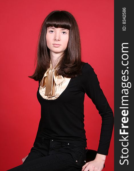 Happy girl sitting on a chair in studio