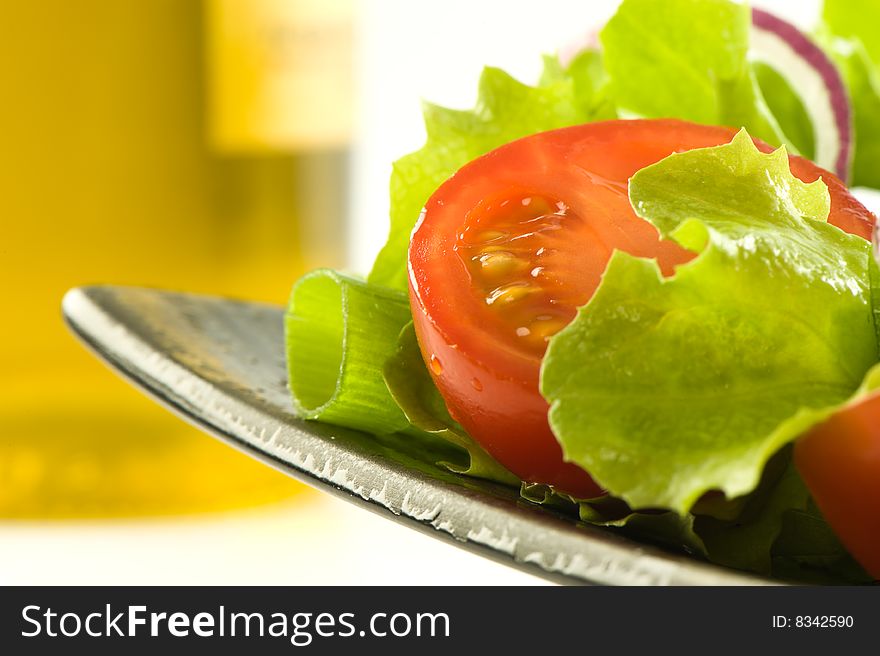 Healthy fresh salad isolated on plate. Bottle of olive oil on background. Healthy lifestyle. Healthy fresh salad isolated on plate. Bottle of olive oil on background. Healthy lifestyle.