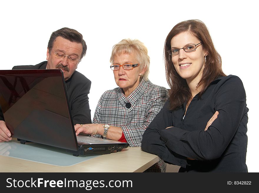 A business team of three sitting in front of a laptop. Focus is on the young woman in front. Isolated over white. A business team of three sitting in front of a laptop. Focus is on the young woman in front. Isolated over white.