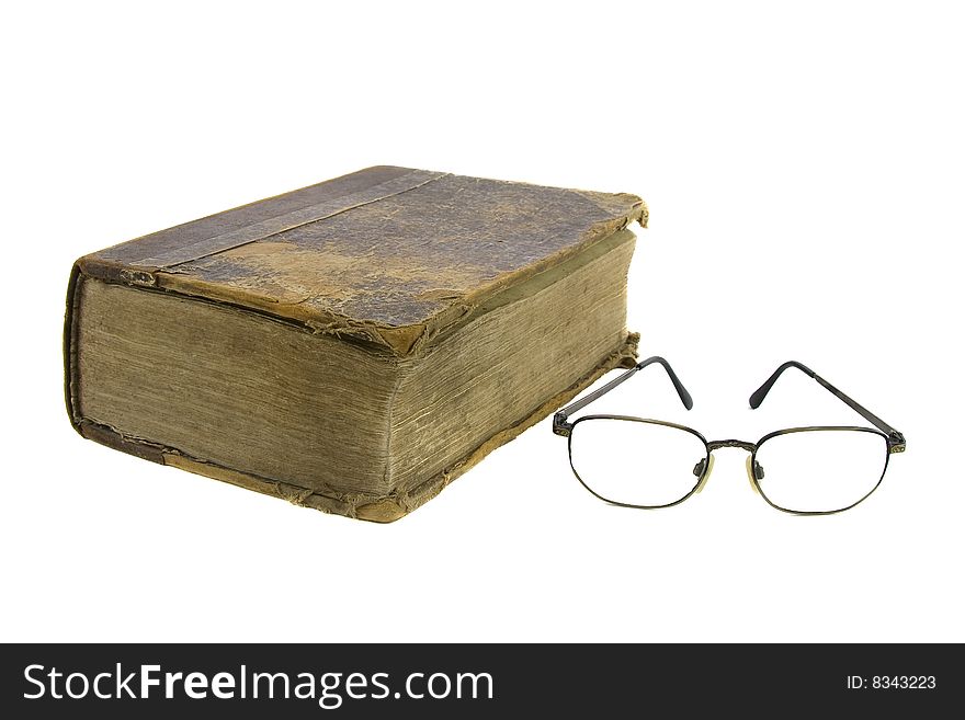 Glasses near very old bible on the white background