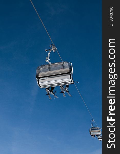 Shot from below a chairlift against blue sky. Shot from below a chairlift against blue sky