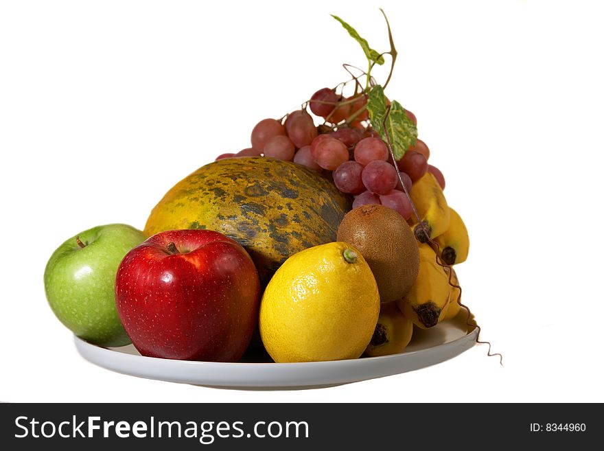 Juicy plate of Fruits: banana, melon, apples, lemon, grapes, mandarin