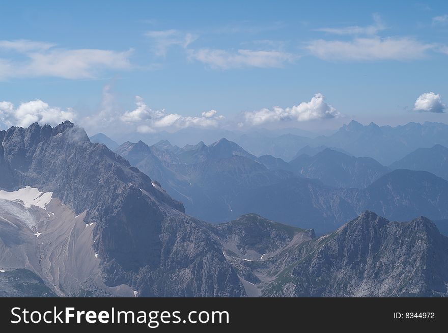 Alpine mountains landscape with haze and clouds. Alpine mountains landscape with haze and clouds