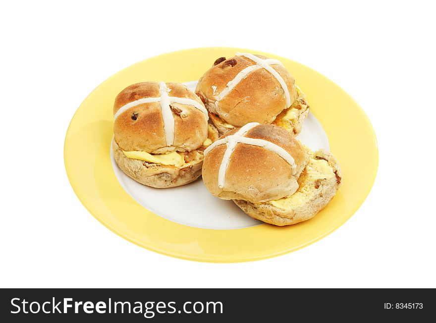 Three toasted and buttered hot cross buns on a plate