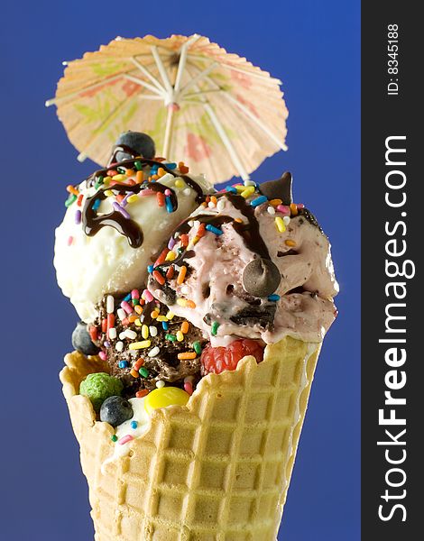 Close up shot of nice ice cream with umbrella on blue background