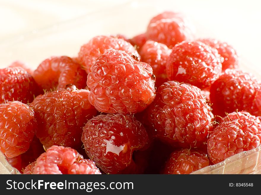 Heap of a lot of fresh raspberries on white background